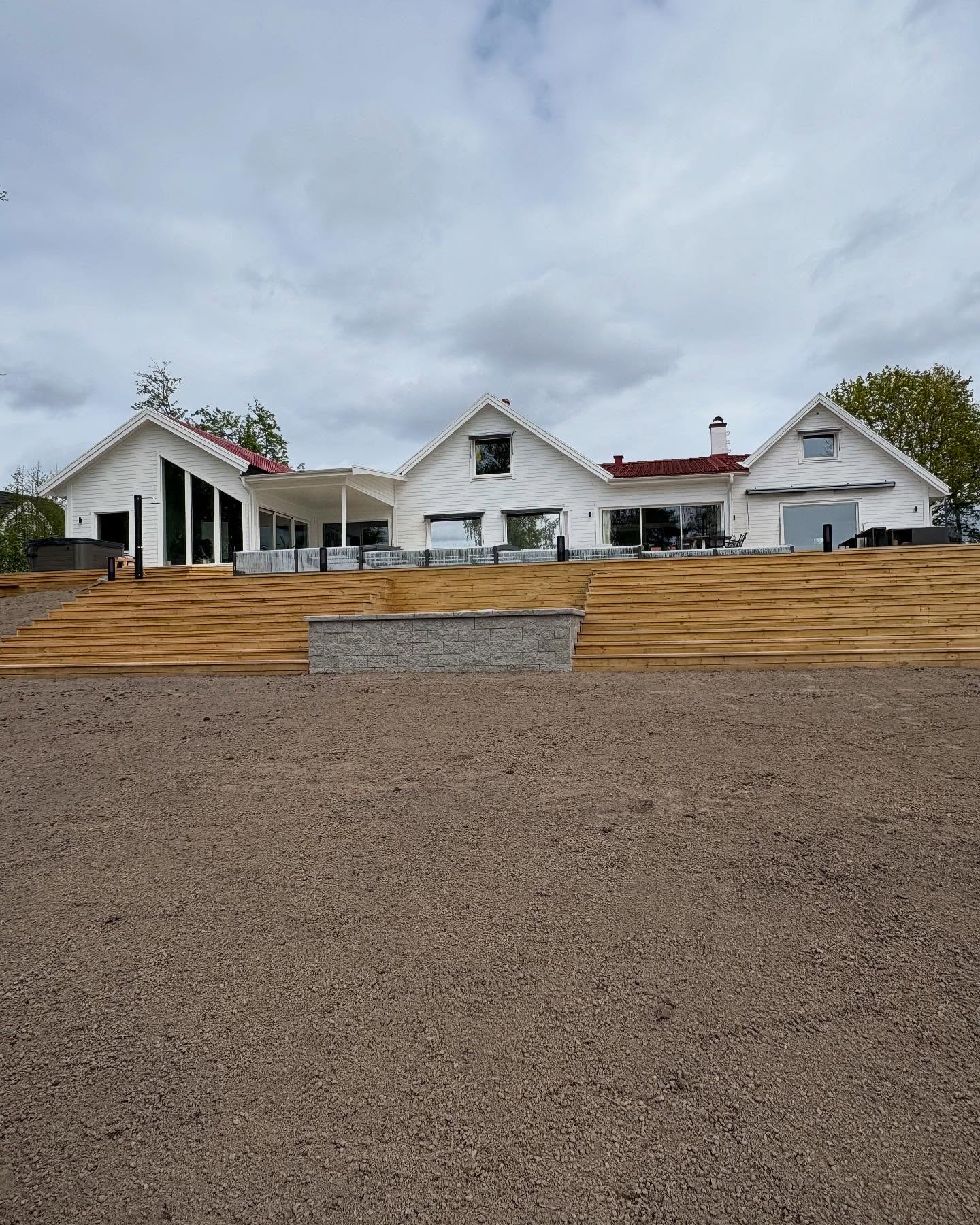 Altantrappa i trä med inbyggd grillplats, mursten och gräsmatta utförd av VE Markentreprenad